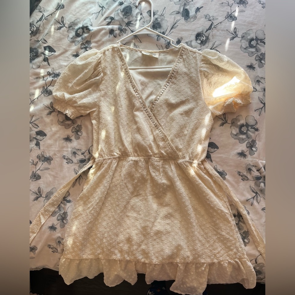 A white-cream colored dress with waist belt and clasp in the front.